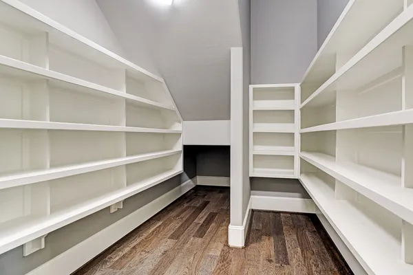 a view of walk in closet with empty racks