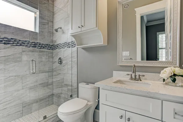 a bathroom with a granite countertop sink a toilet and a shower