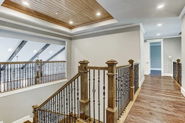 a view of a hallway with wooden floor and stairs