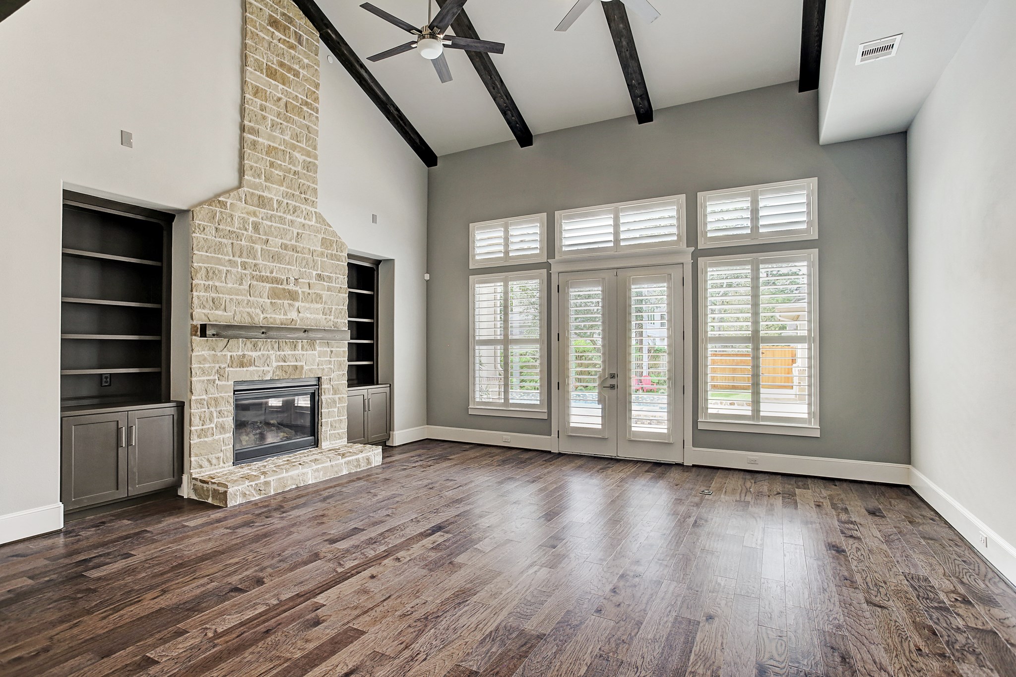 325 Bunker Hill Road Houston, TX 77024 - Photo 8 of 50 an empty room with wooden floor fireplace and windows