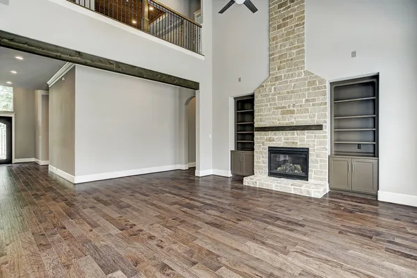 an empty room with wooden floor a fireplace
