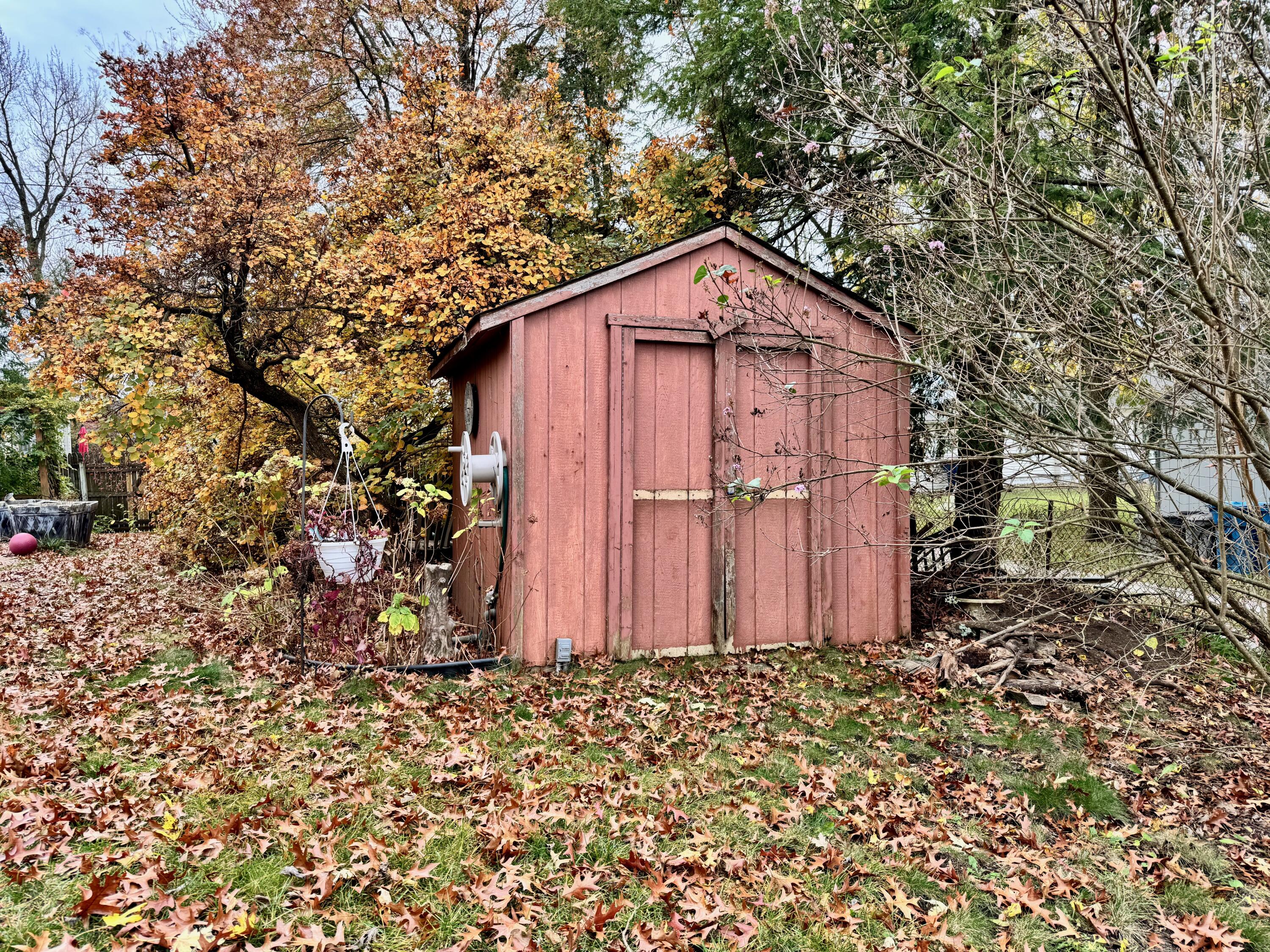 703 South Main Street Knox, IN 46534 - Photo 29 of 32 a view of a small barn with wooden fence and large trees