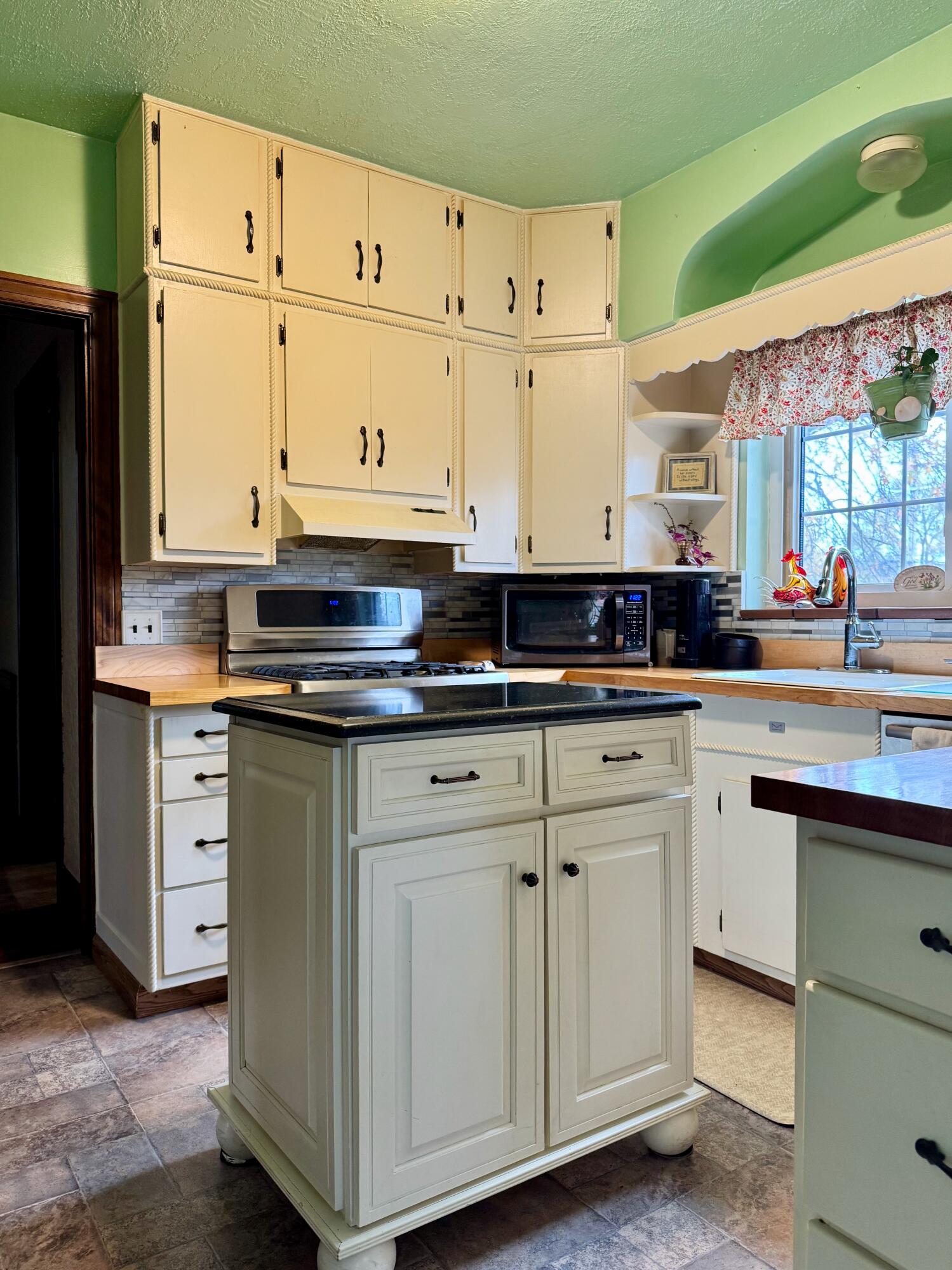 703 South Main Street Knox, IN 46534 - Photo 9 of 32 a kitchen with granite countertop white cabinets and white appliances