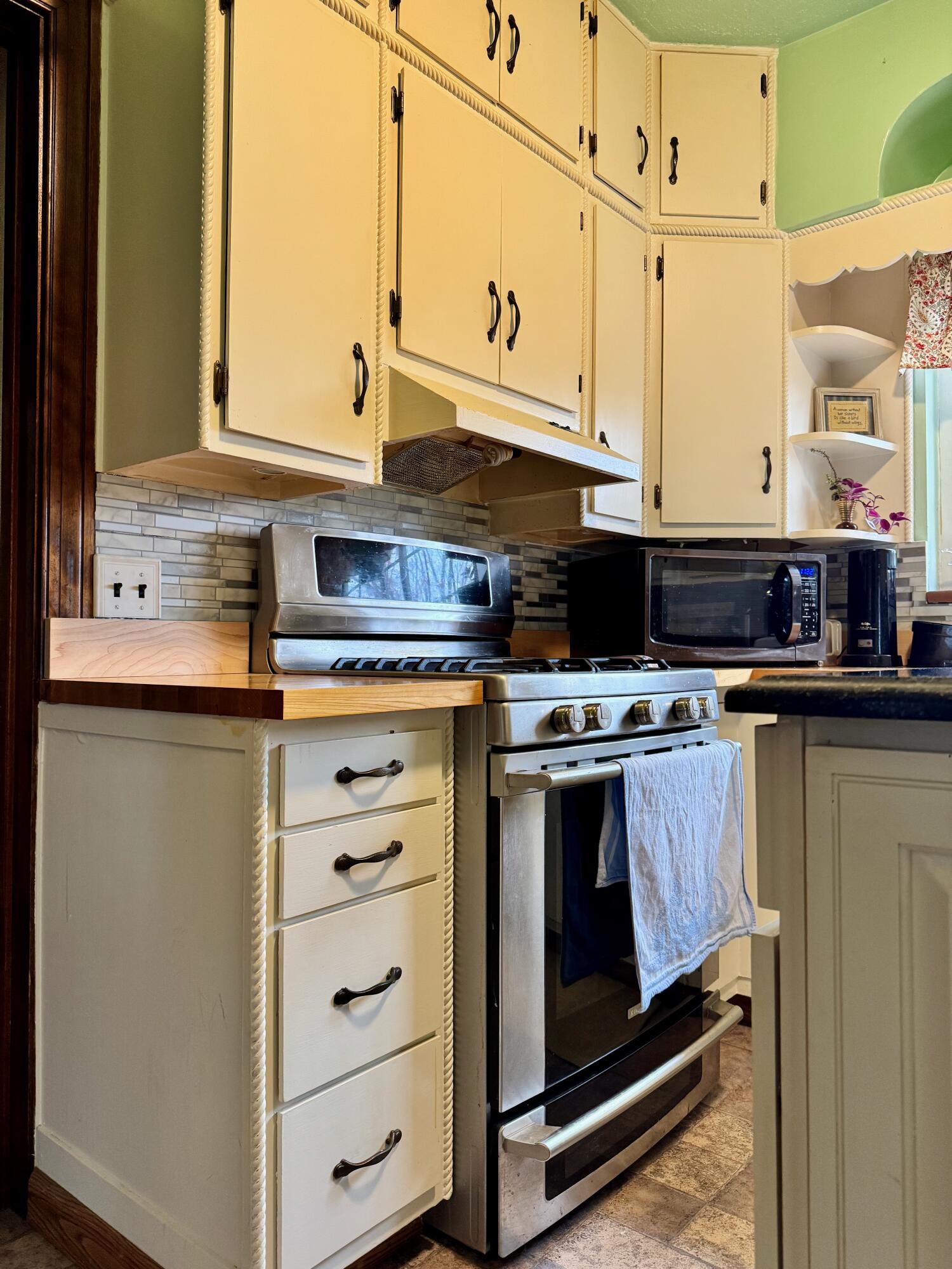 703 South Main Street Knox, IN 46534 - Photo 10 of 32 a kitchen with stainless steel appliances granite countertop a stove and a microwave