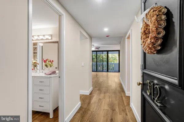 a view of a hallway to a livingroom with wooden floor