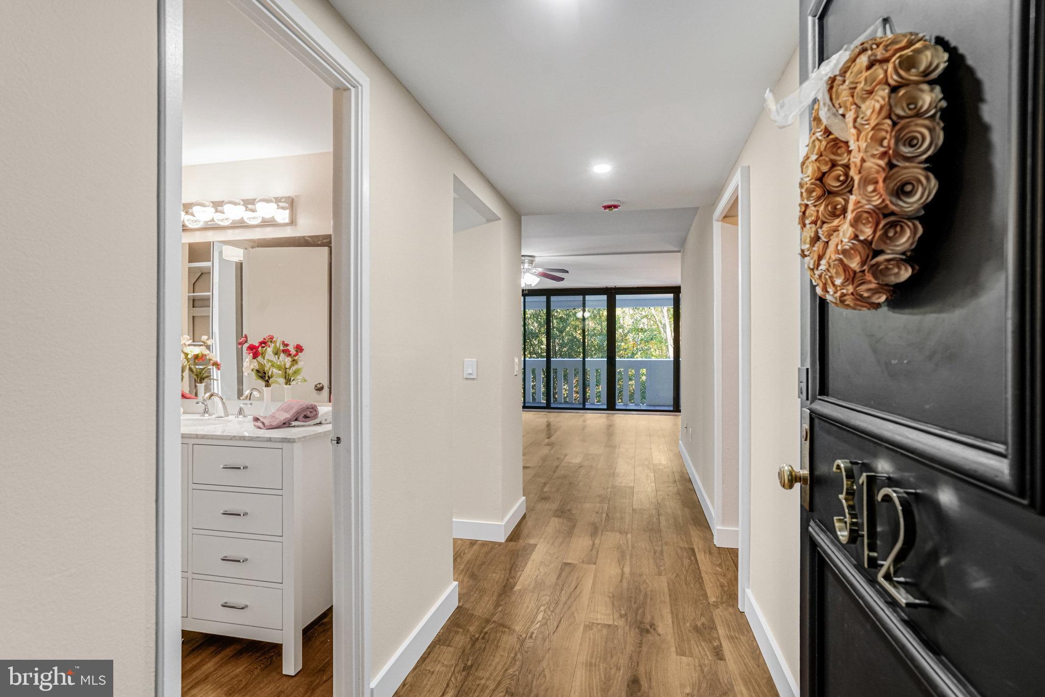 a view of a hallway to a livingroom with wooden floor
