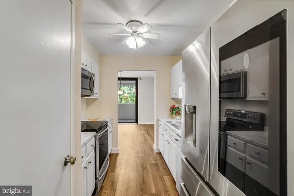 a kitchen with granite countertop a sink a stove and cabinets