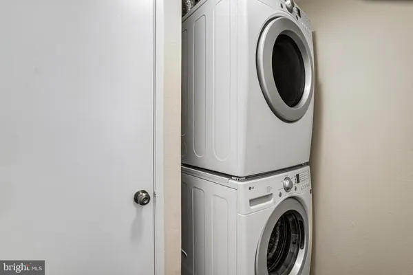 a view of an empty room with wooden floor and a bathroom