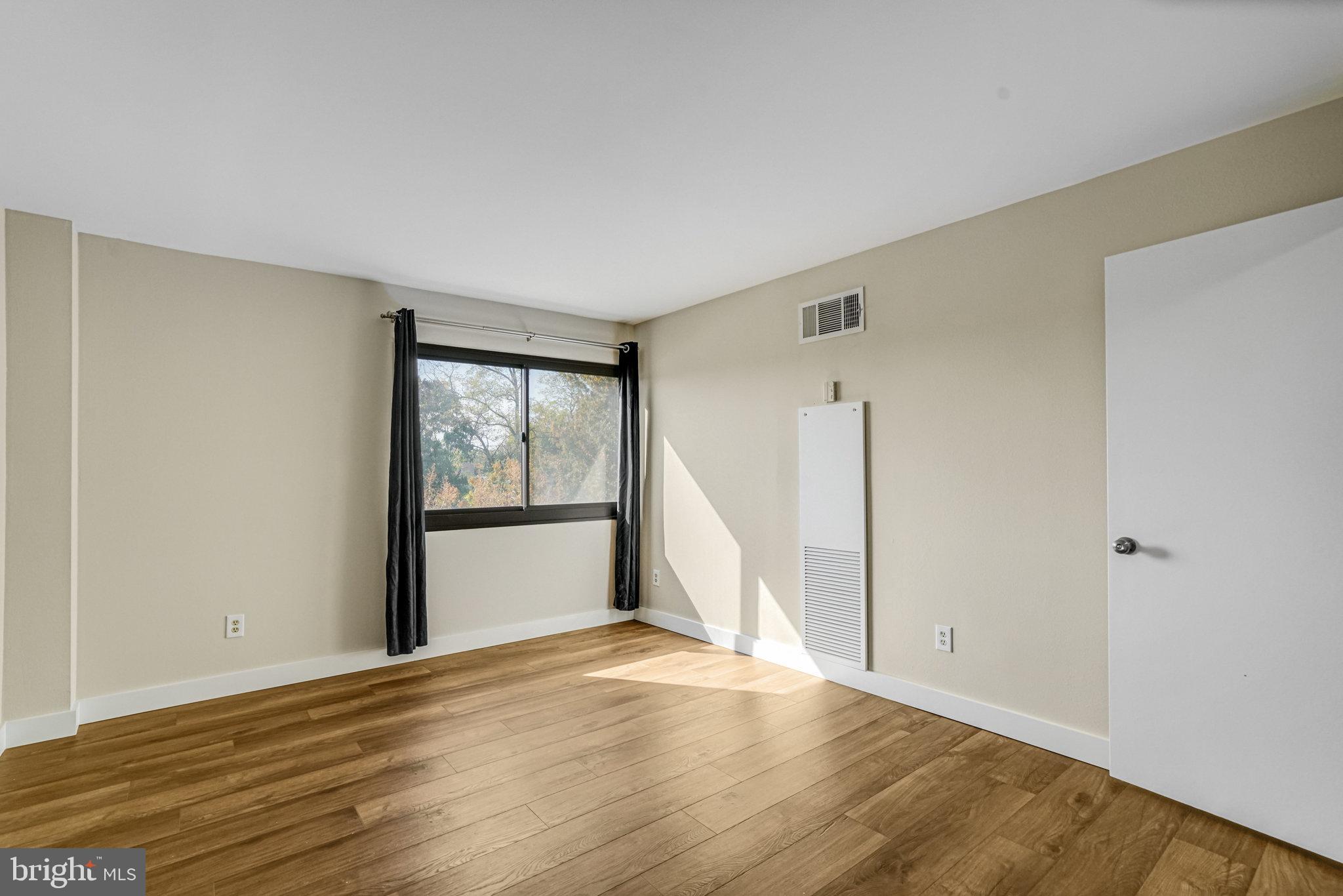 6101 Edsall Road, Unit 312 Alexandria, VA 22304 - Photo 23 of 57 a view of an empty room with wooden floor and a window