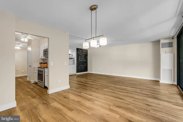 a view of a kitchen with a sink and dishwasher with wooden floor