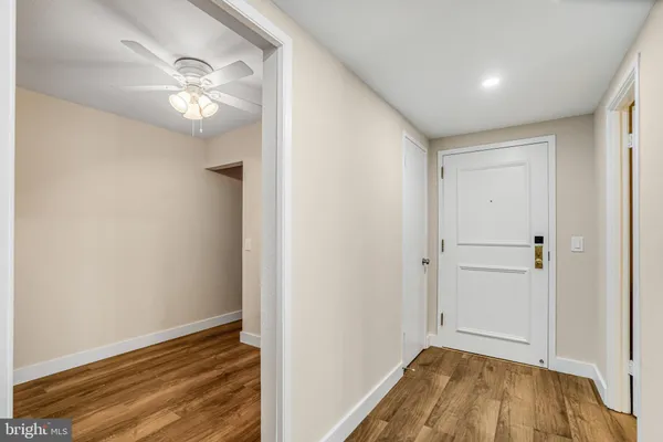 a view of a hallway with wooden floor and staircase