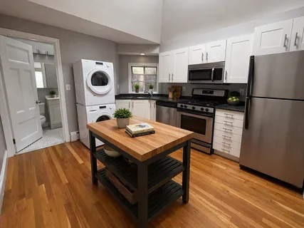 a kitchen with a refrigerator a stove top oven a sink dishwasher and wooden floor