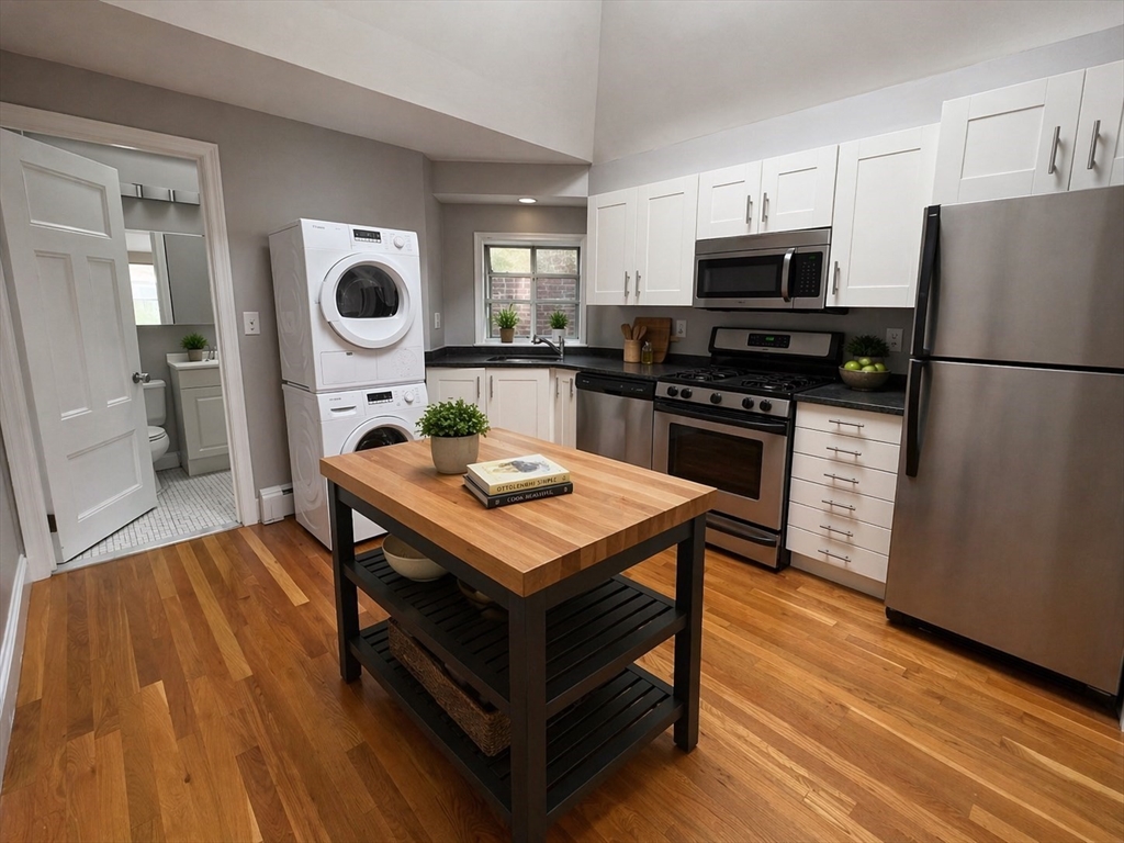 198 St Botolph Street, Unit 8 Boston, MA 02115 - Photo 2 of 7 a kitchen with a refrigerator a stove top oven a sink dishwasher and wooden floor