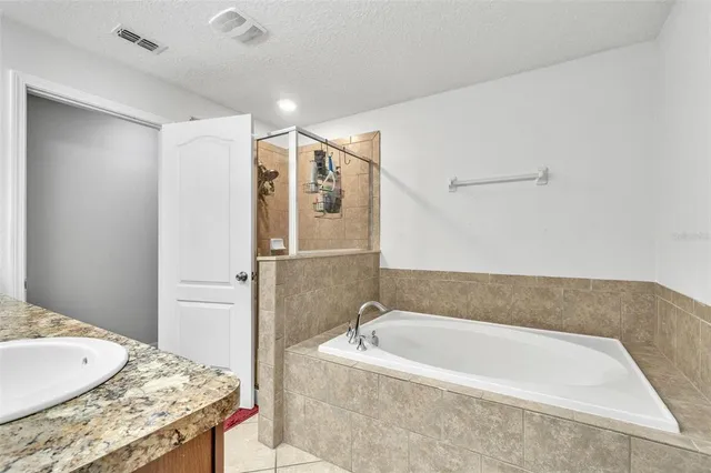 a bathroom with a granite countertop sink a mirror and shower