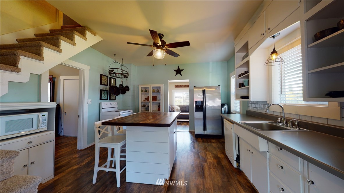 17815 Dunbar Road Mount Vernon, WA 98273 - Photo 17 of 29 a kitchen with stainless steel appliances granite countertop a sink a stove and chairs with wooden floor