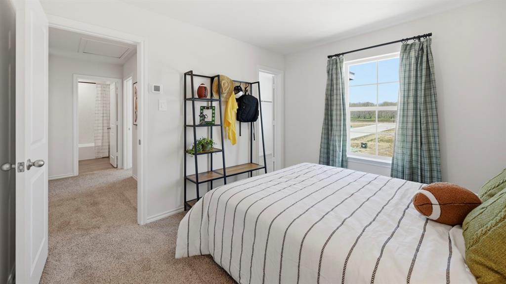 1957 Freeman Street Tyler, TX 75704 - Photo 20 of 25 Carpeted bedroom featuring a large window with exterior views, white walls, and a built-in wall shelf with wood-finish shelving