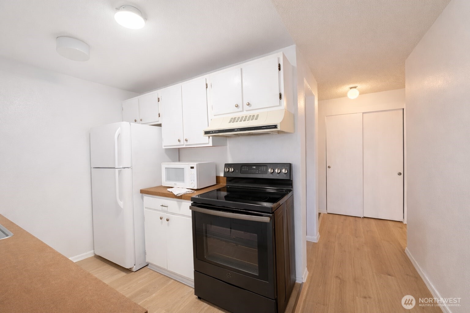 318 South 174th Place, Unit K Burien, WA 98148 - Photo 6 of 12 a kitchen with stainless steel appliances white cabinets and a refrigerator