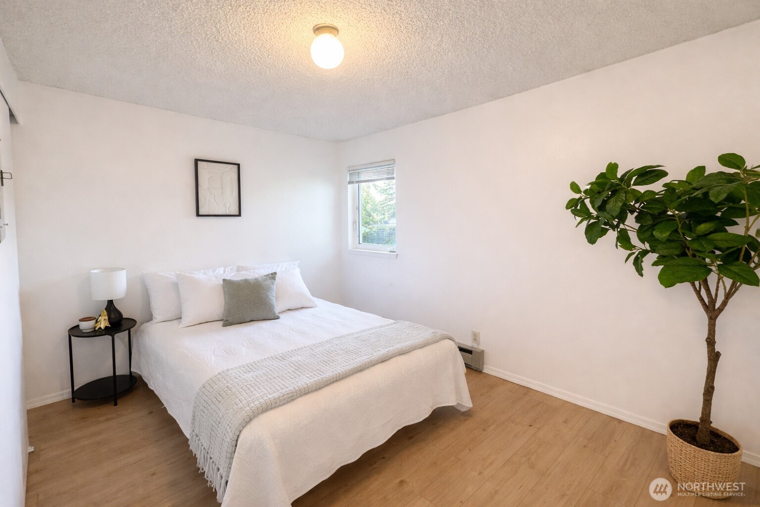 318 South 174th Place, Unit K Burien, WA 98148 - Photo 8 of 12 a bedroom with a bed and a potted plant