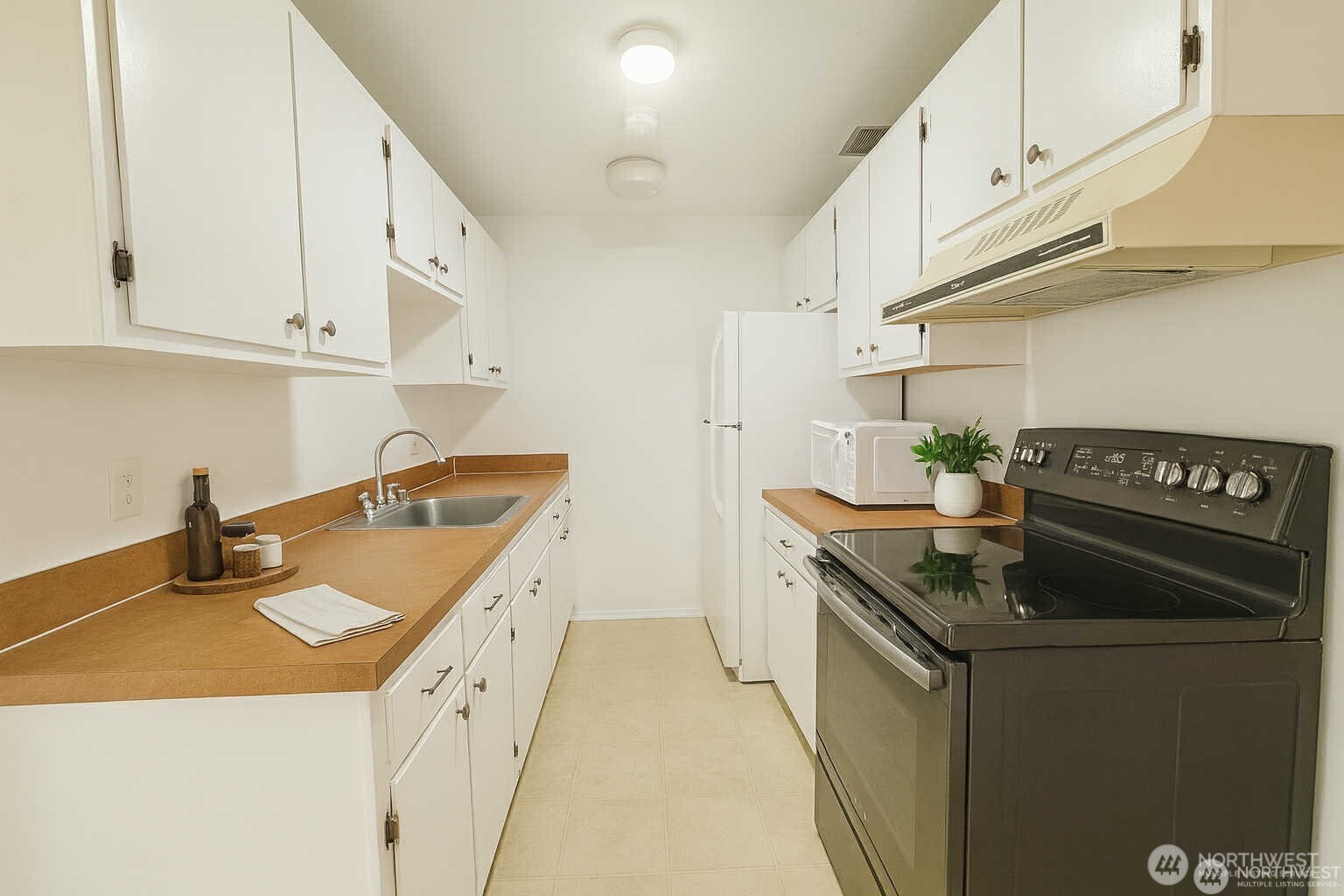 318 South 174th Place, Unit K Burien, WA 98148 - Photo 10 of 12 a kitchen with granite countertop a sink a stove and cabinets