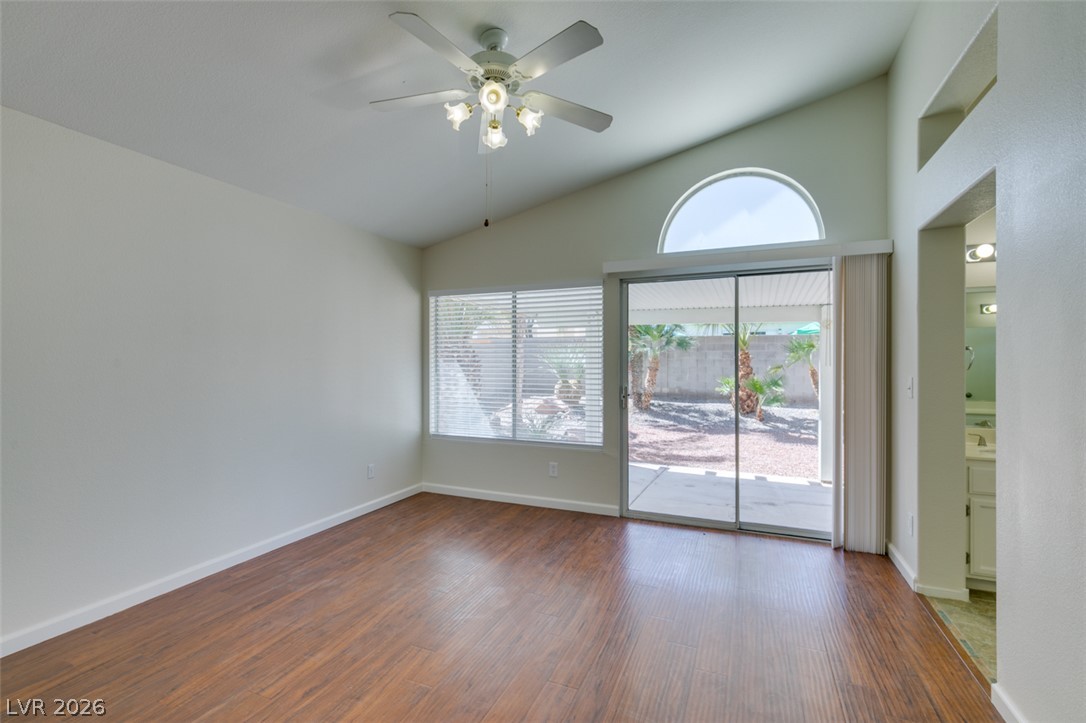 307 Cavalla Street Henderson, NV 89074 - Photo 34 of 44 Hardwood floors and vaulted ceilings elevate this primary bedroom with outdoor access.