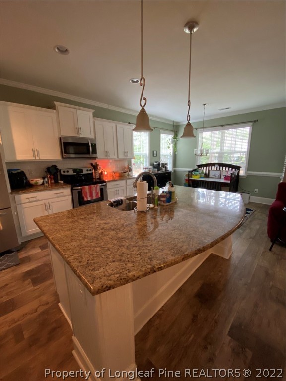 144 Moultrie Lane Aberdeen, NC 28315 - Photo 8 of 49 a kitchen with stainless steel appliances granite countertop a sink a stove and a wooden floor
