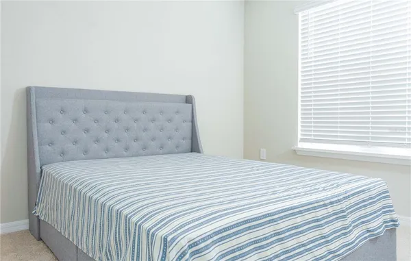 a bedroom with a window and a chair