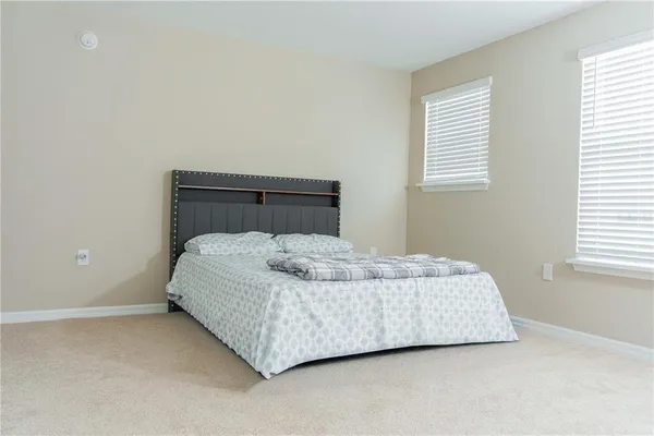 a bedroom with a white bed and a night stand