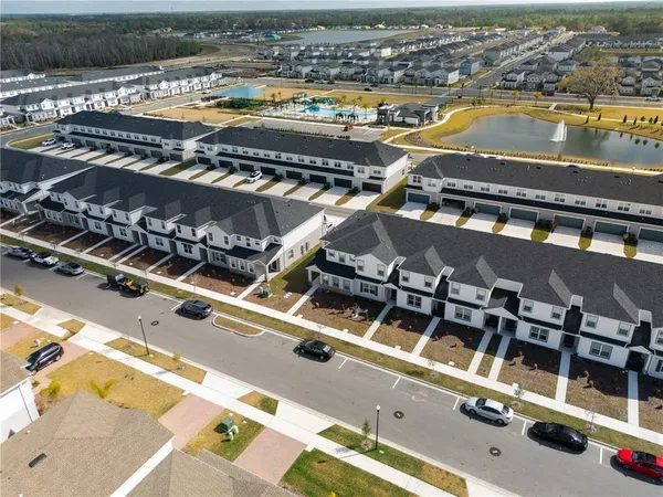 an aerial view of a residential apartment building with a swimming pool and outdoor seating