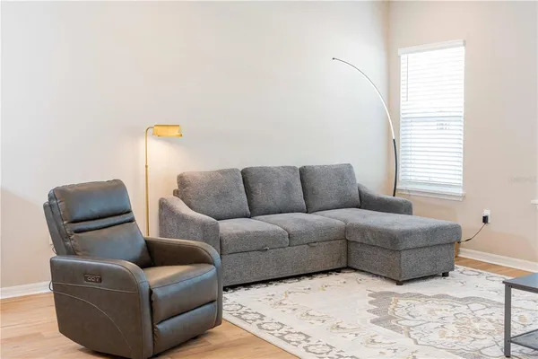 a room with stainless steel appliances kitchen island granite countertop a dining table chairs sink refrigerator and microwave