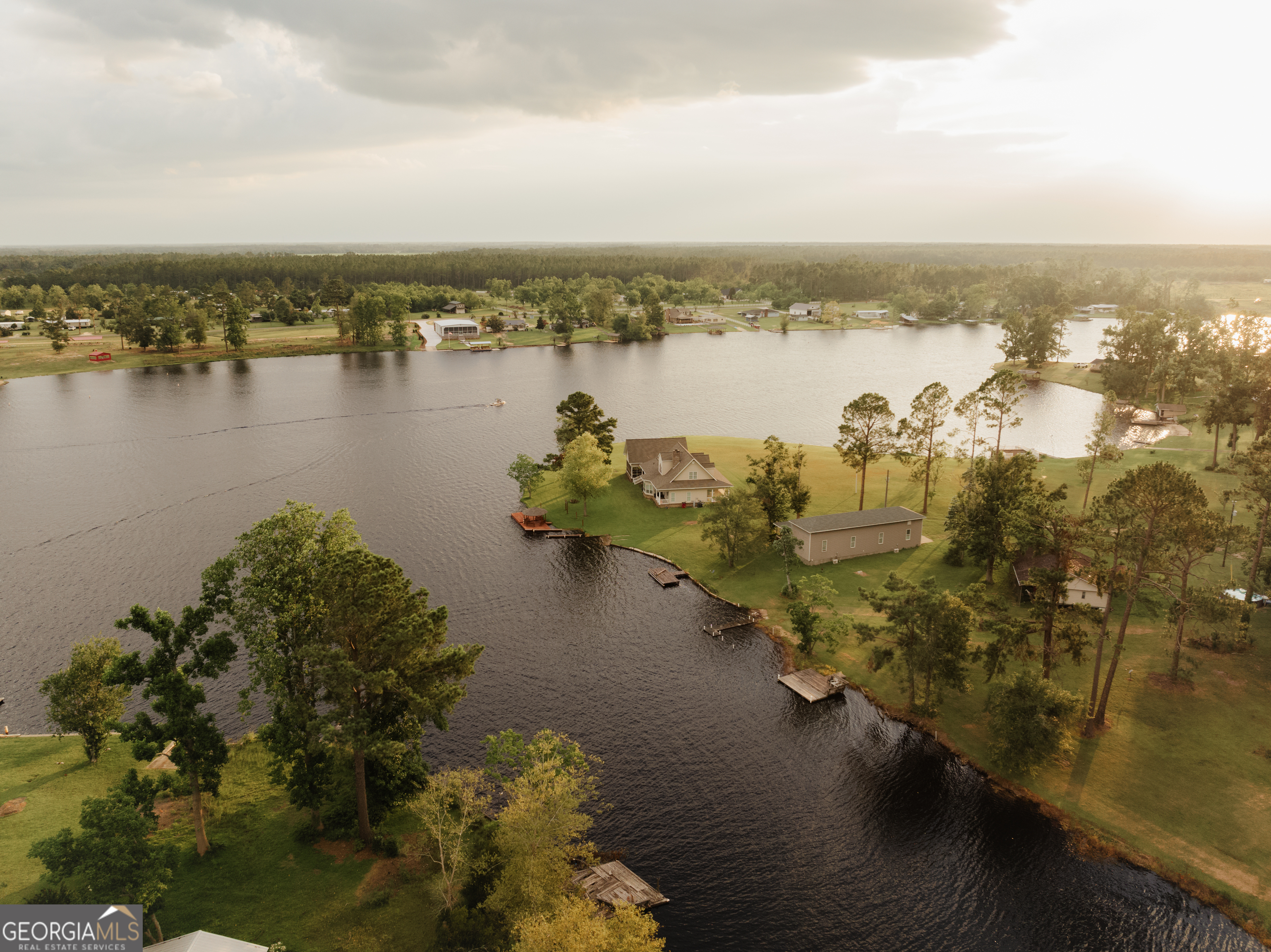 a view of a ocean with boats and trees in all around