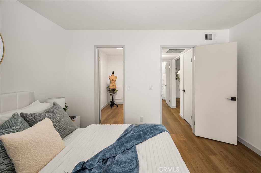 3010 Associated Road, Unit 122 Fullerton, CA 92835 - Photo 8 of 17 a bedroom with a bed and wooden floor