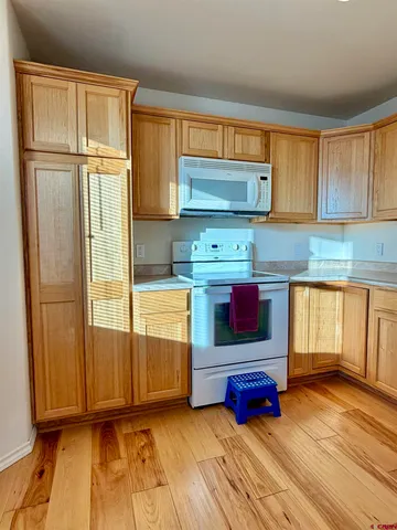 a kitchen with granite countertop a stove and a wooden floor