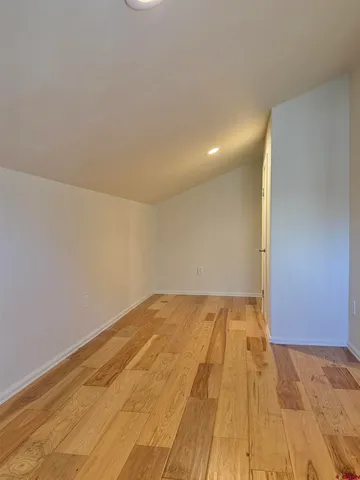 a view of empty room with wooden floor