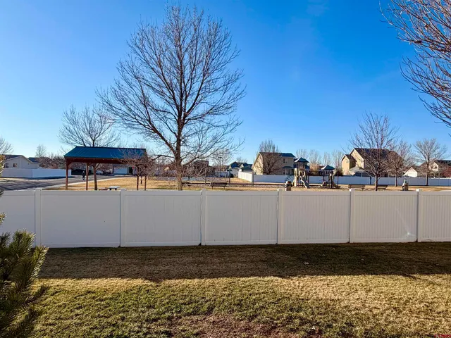 a view of a yard with wooden fence