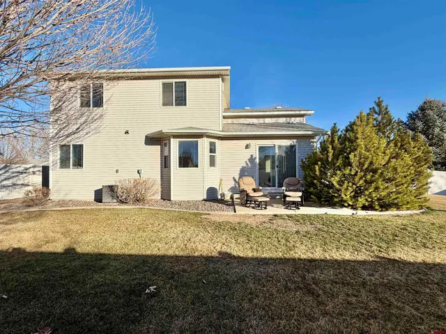 a view of a house with backyard and sitting area