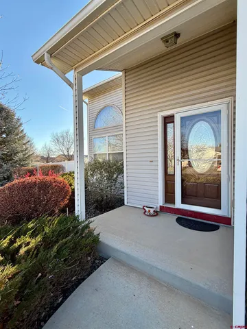 a front view of a house with a yard and potted plants
