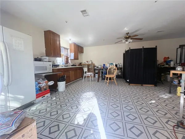a living room with stainless steel appliances kitchen island granite countertop furniture and a refrigerator