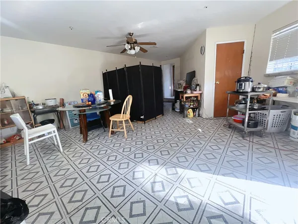 a living room with furniture a dining table and chair with the kitchen view