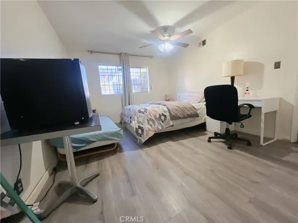 a bedroom with bed tv and window