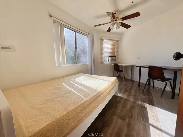 a bed sitting in a spacious bedroom next to a window