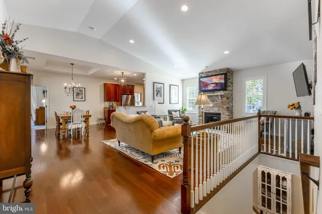 a dining room with furniture a chandelier and wooden floor