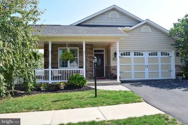 a front view of a house with a garden and plants