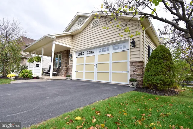 a view of a house with a yard and large tree