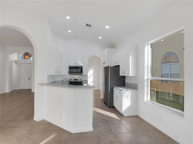 a living room with stainless steel appliances kitchen island furniture and a fireplace