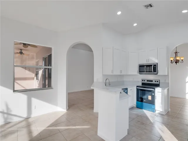 a open kitchen with stainless steel appliances granite countertop a stove and a sink