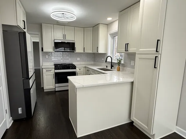 a kitchen with a sink a refrigerator a microwave a sink and cabinets