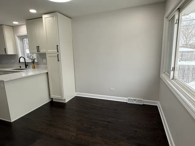 a view of a kitchen with a sink wooden floor and a window