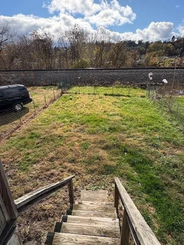 a view of a roof deck with couches and wooden fence