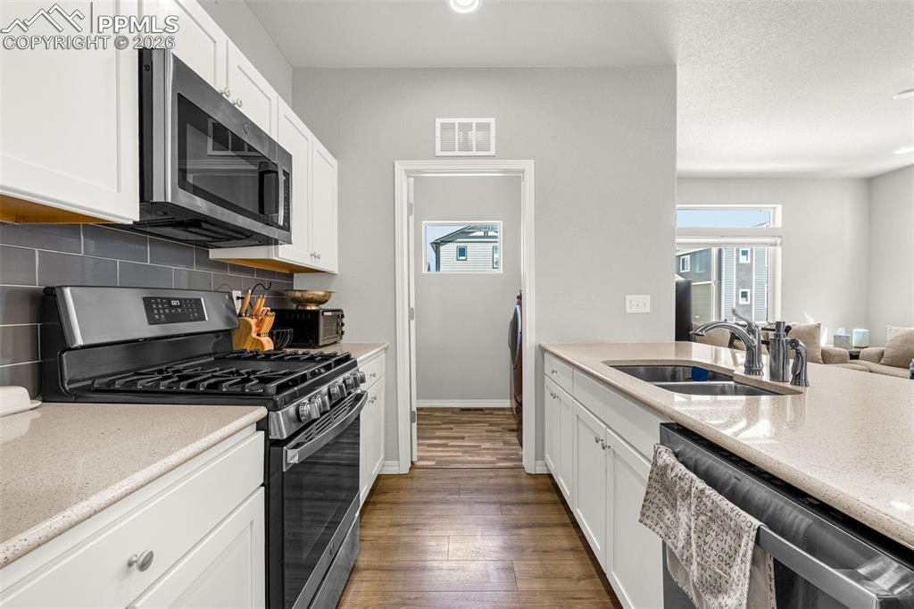 4432 Samaritan Loop Colorado Springs, CO 80916 - Photo 11 of 20 a kitchen with stainless steel appliances granite countertop a stove a sink and a microwave