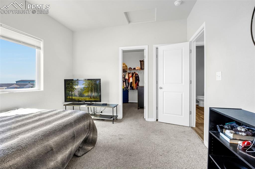 4432 Samaritan Loop Colorado Springs, CO 80916 - Photo 15 of 20 a bedroom with a bed and a flat tv screen on wall